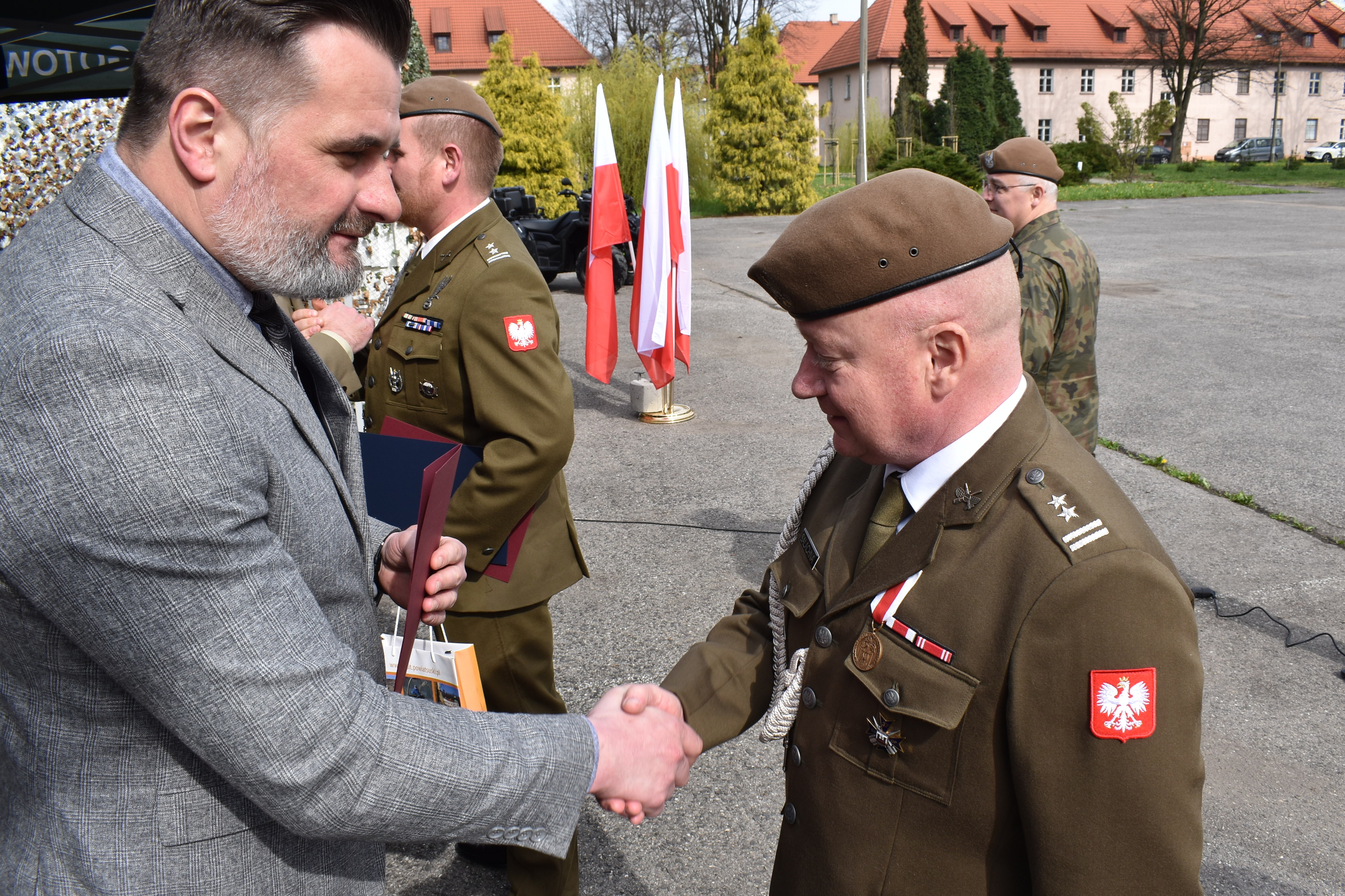 Na zdjęciu wicestarosta gratuluje i ściska dłoń nowego dowódcy terytorialsów w Oświęcimiu