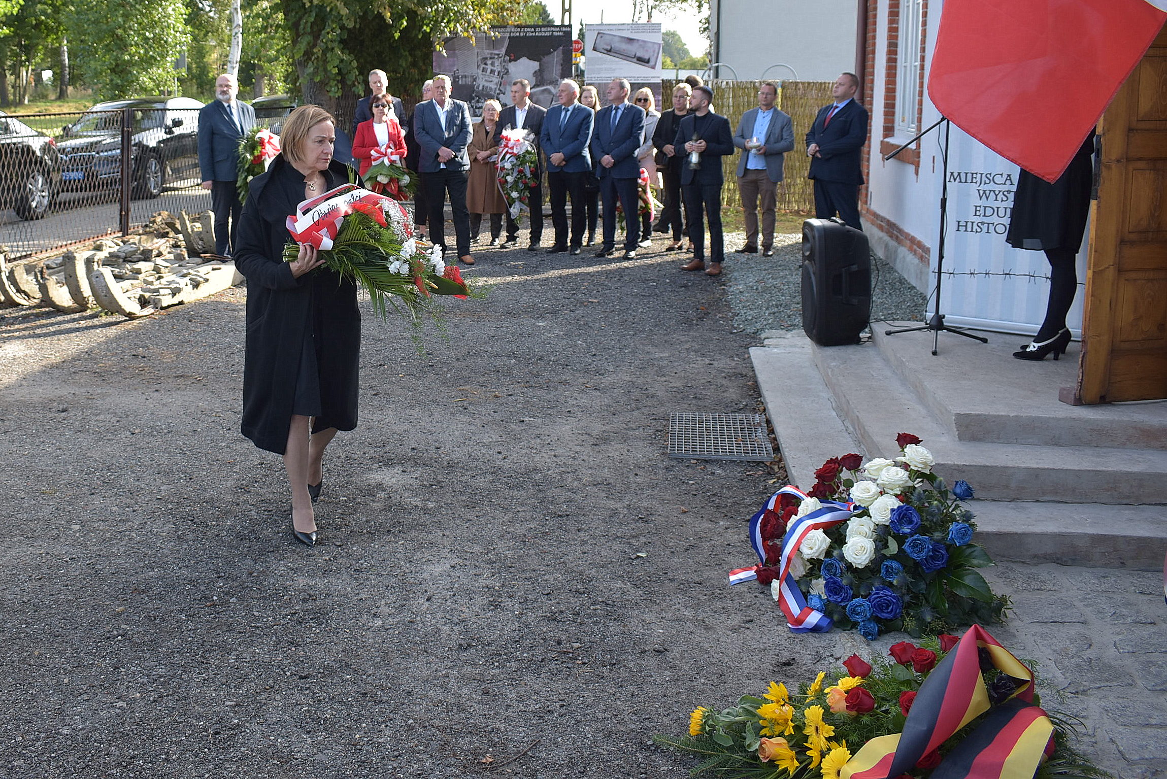 Członek zarządu powiatu składa kwiaty pod tablicą upamiętniającą więźniarki karnej kompanii