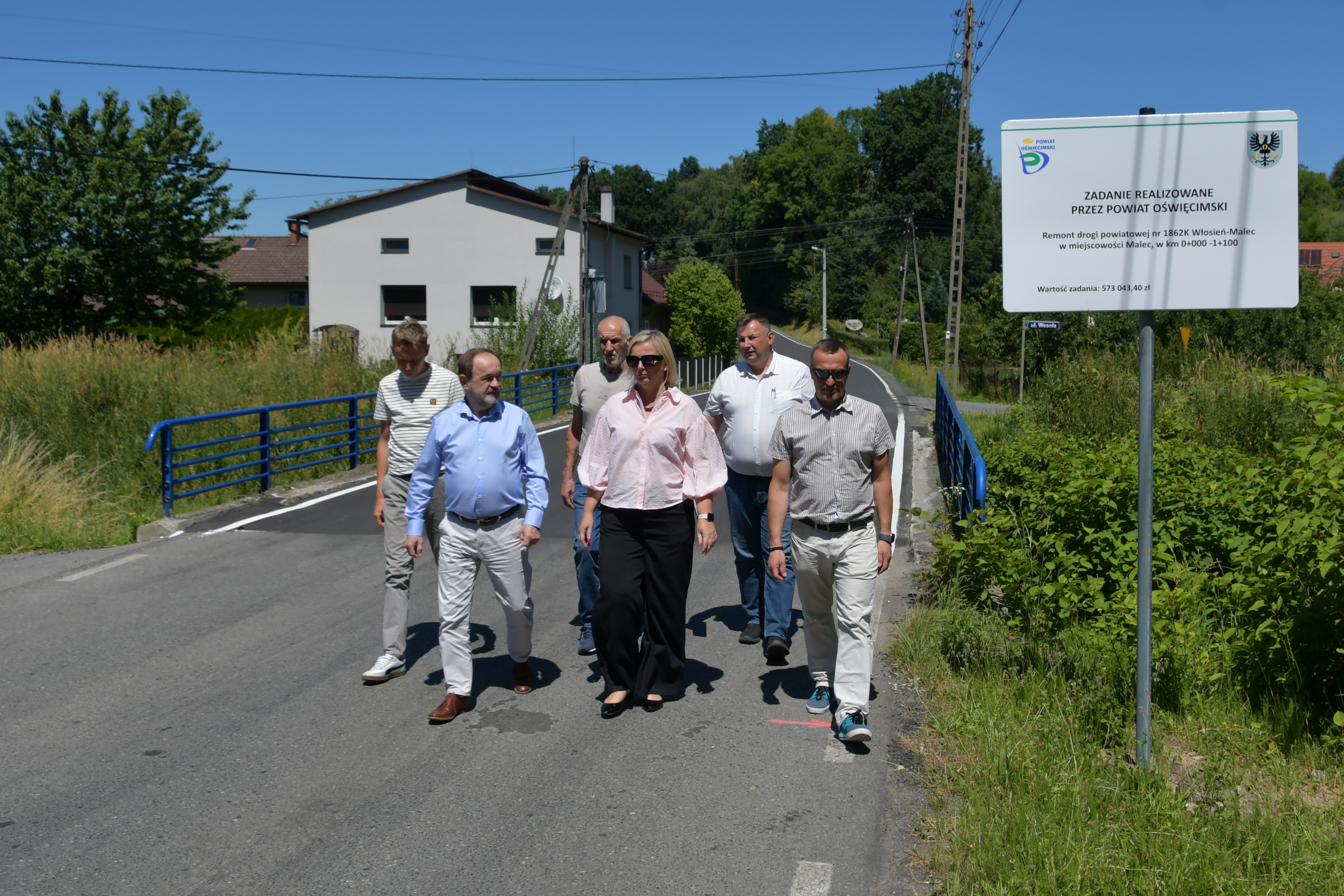 Na zdjęciu idące wyremontowaną drogą uczestnicy odbioru końcowego