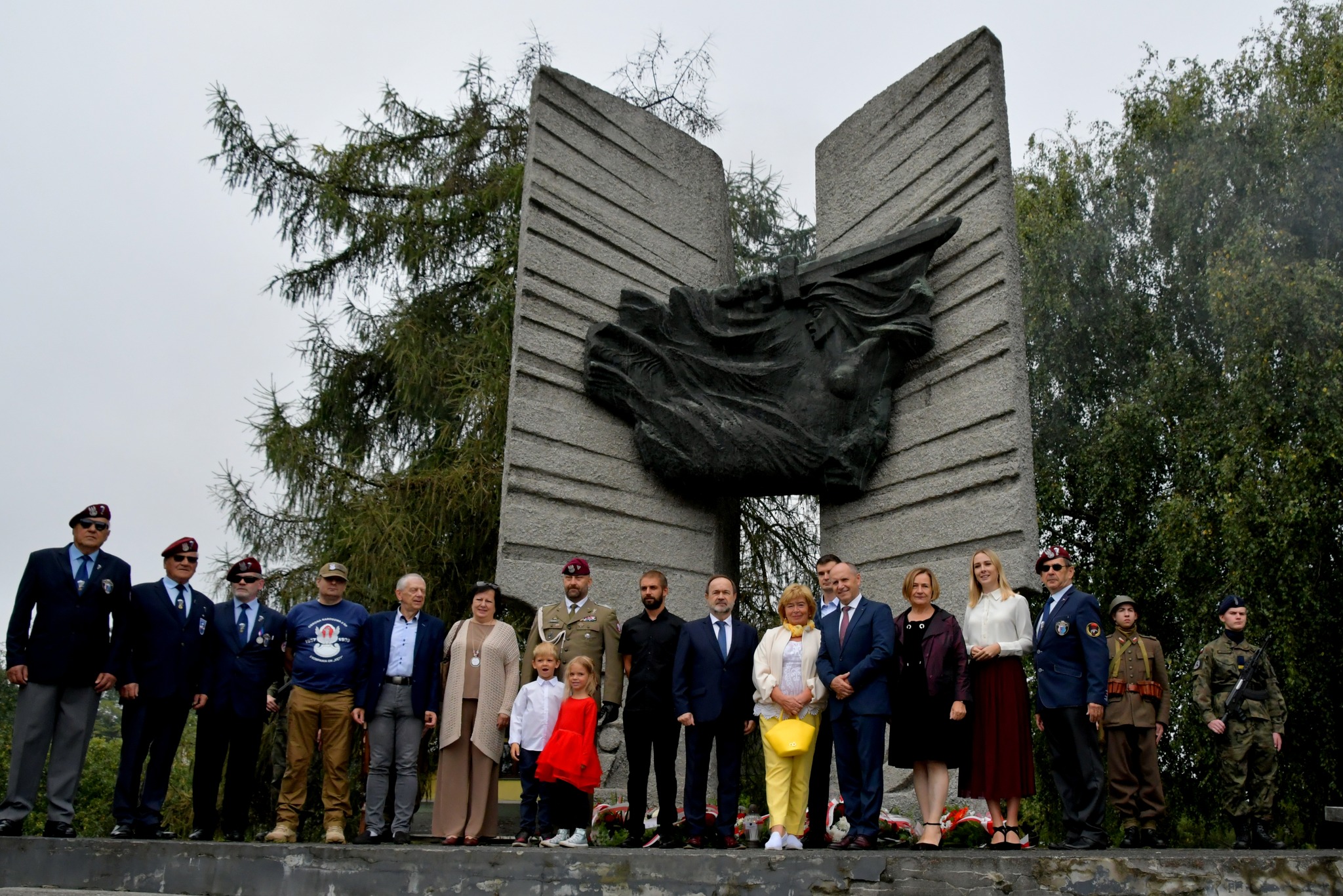 Pamiątkowe zdjęcie uczestników uroczystości na tle pomnika w Rajsku