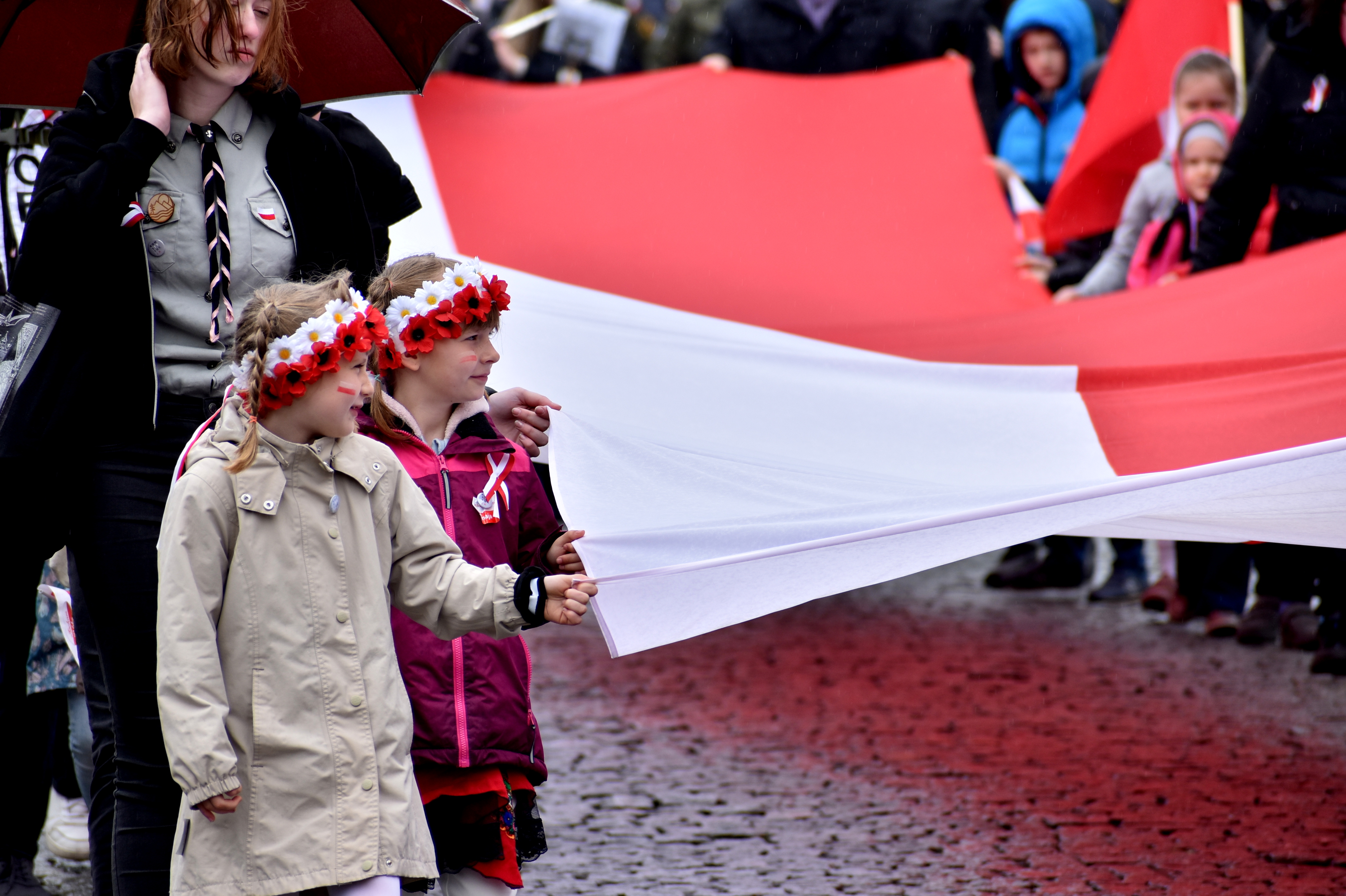 Na zdjęciu dziewczynki trzymające biało-czerwoną flagę