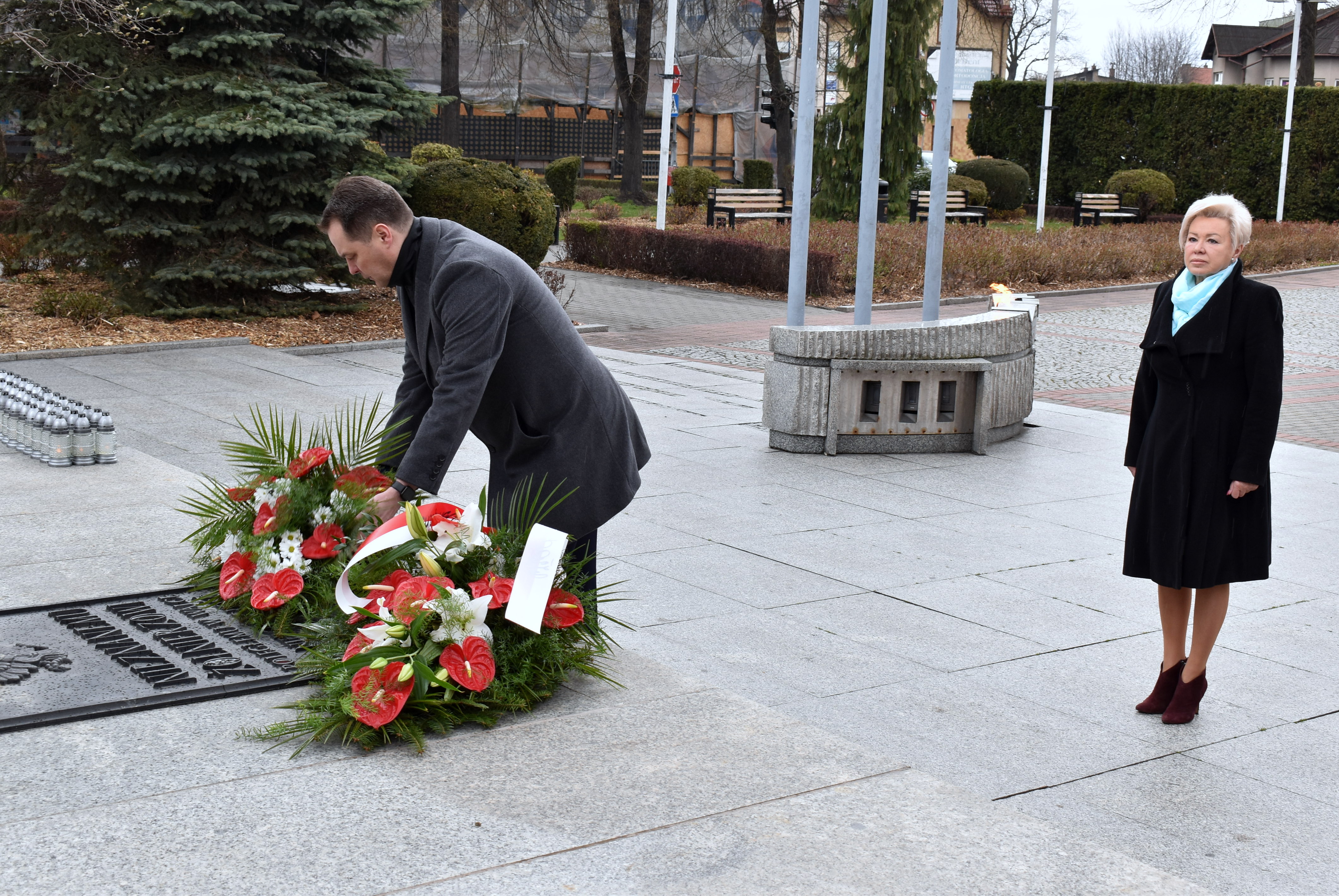 Kwiaty na płycie Grobu Nieznanego Żołnierza w Oświęcimiu składa starosta Andrzej Skrzypiński. Obok stoi członkini zarządu powiatu Grażyna Kopeć.