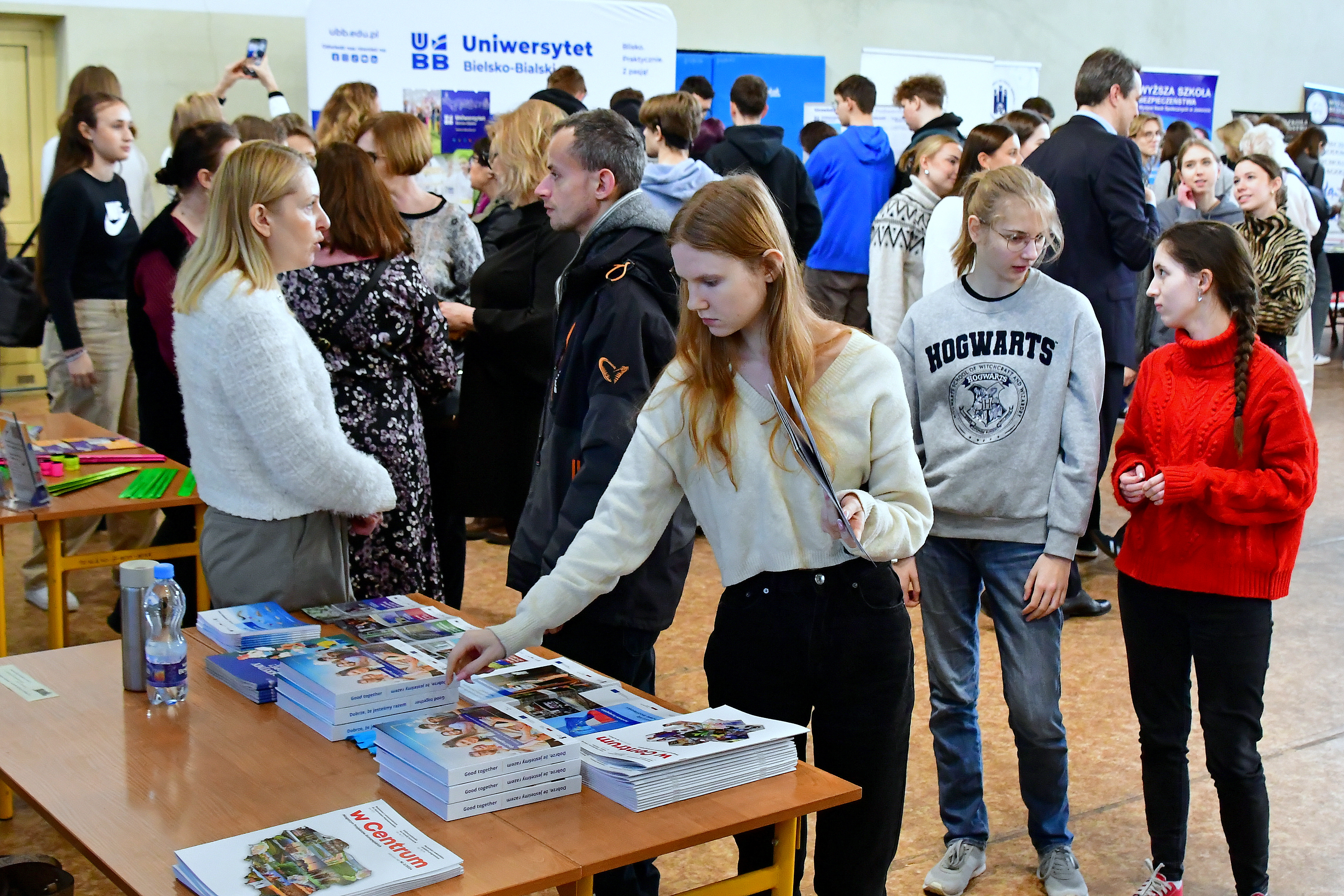 Jedna z uczestniczek Targów sięga po materiały promocyjne. W tle tłumy uczestników imprezy