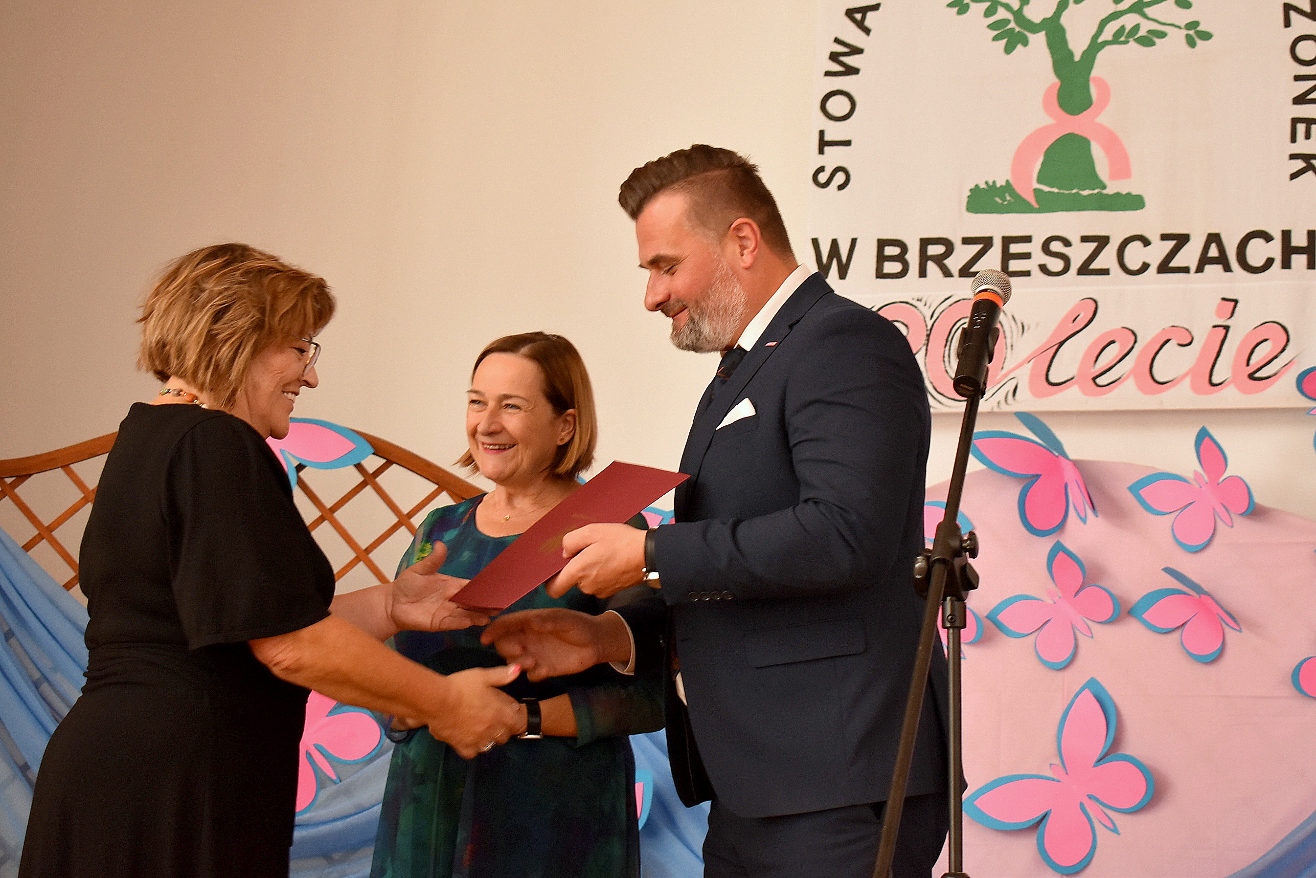 Wicestarosta i członkini zarządu powiatu gratulują prezes stowarzyszenia Amazonek w Brzeszczach