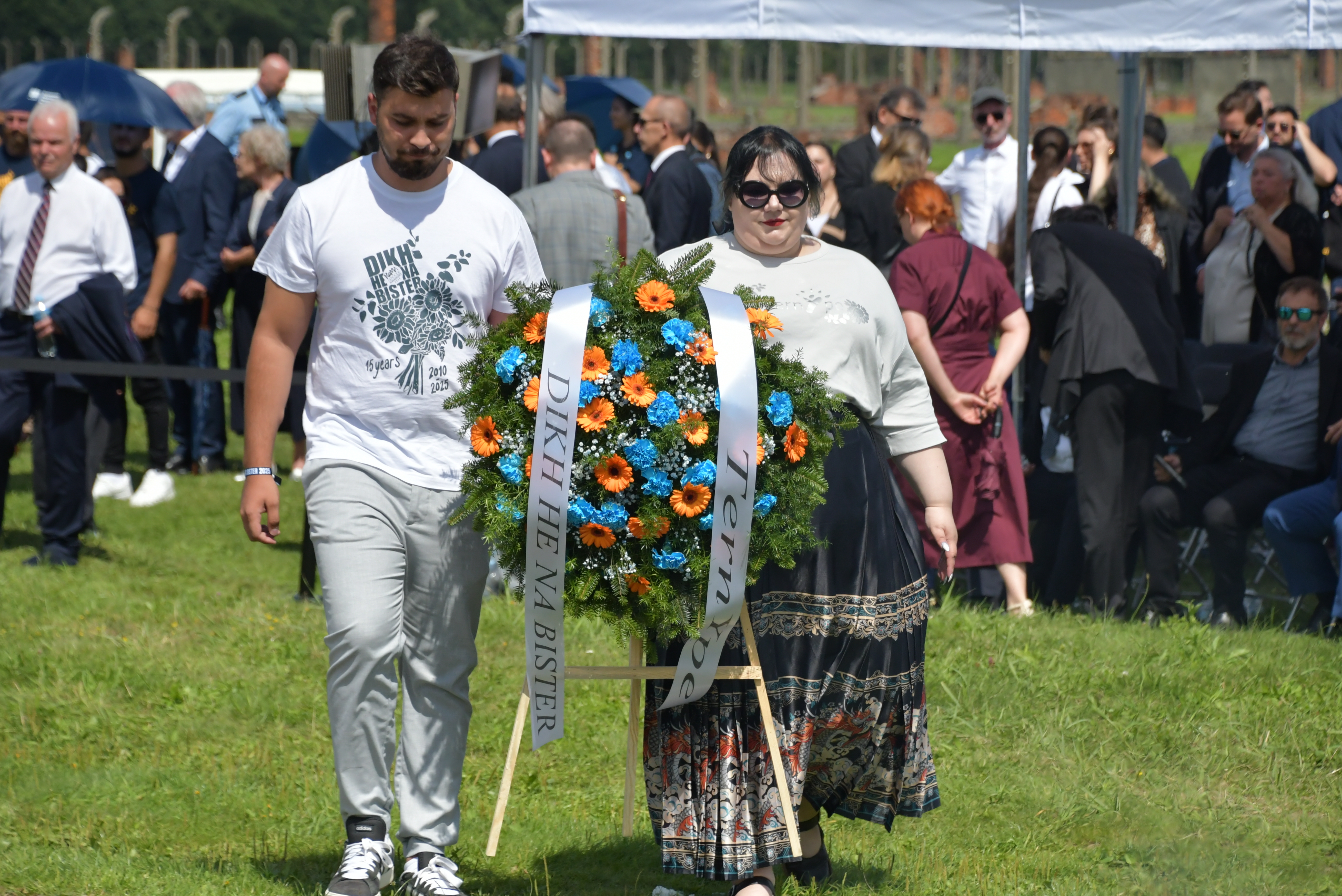 Dwoje Romów z wieńcem upamiętniającym romskie ofiary niemieckich zbrodniarzy