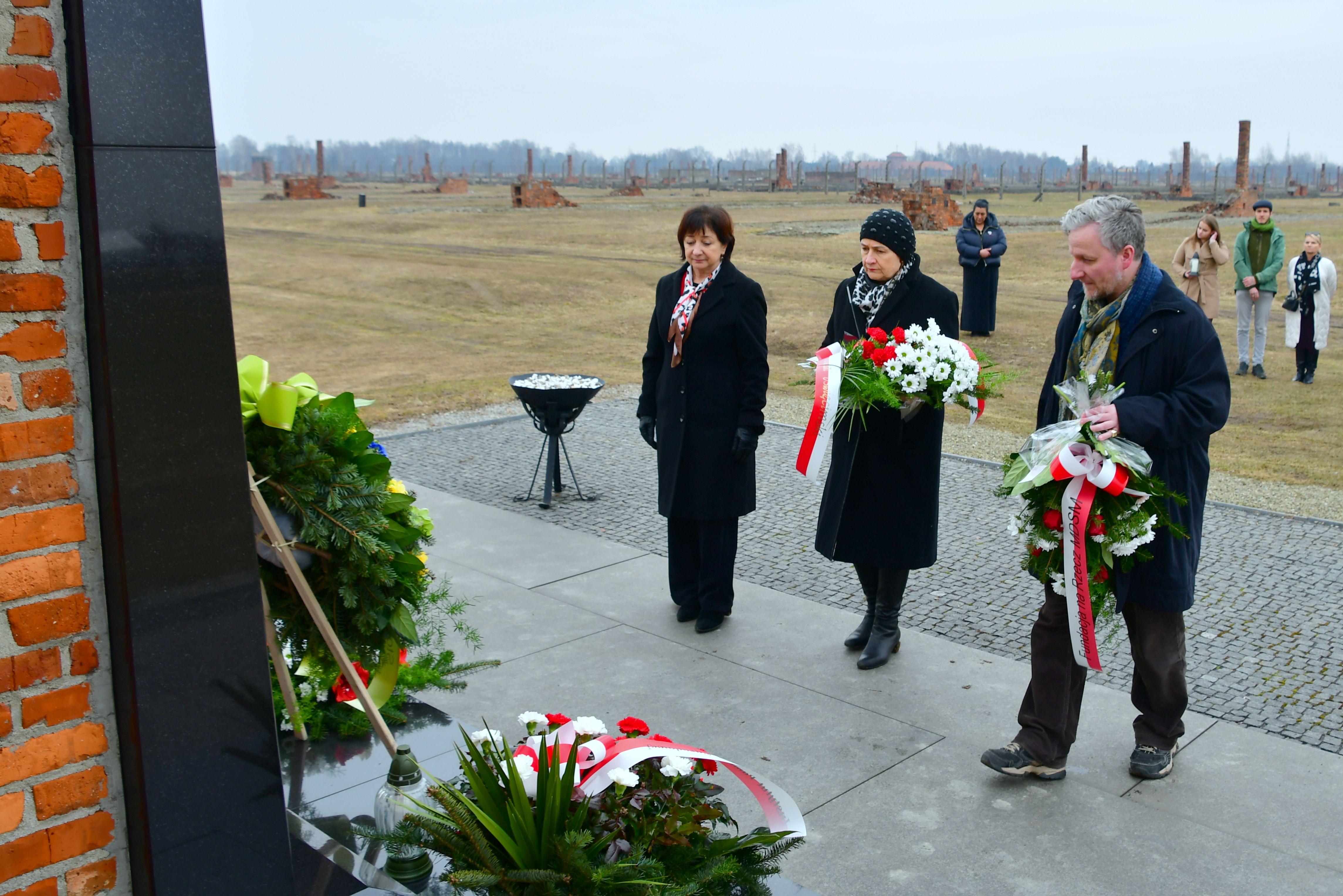 Kwiaty pod pomnikiem na terenie byłego obozu cygańskiego w Birkenau składa delegacja samorządowców, w tym wicestarosta