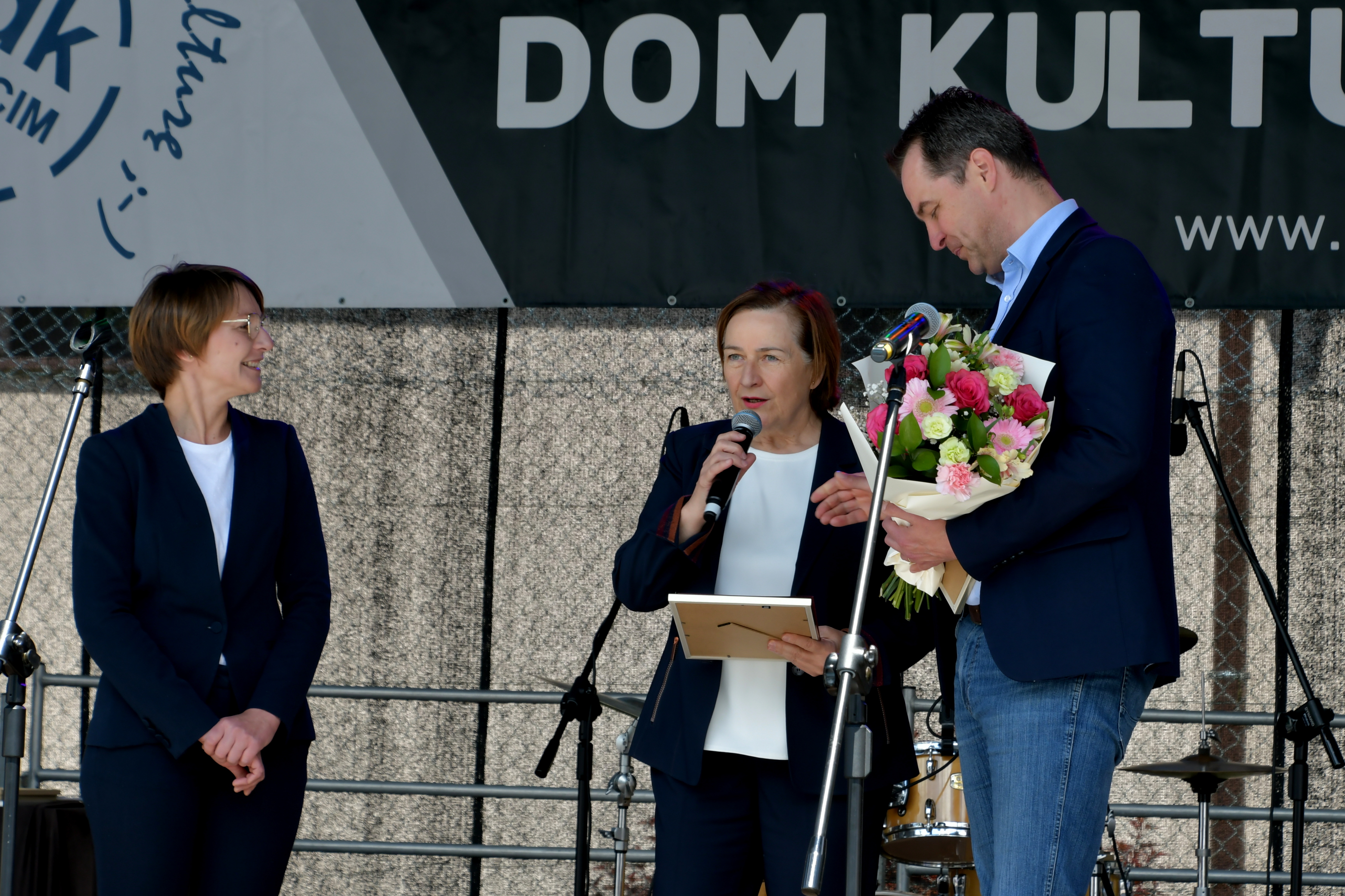 Na scenie starosta i wicestarosta gratulują dyrektorce MDK