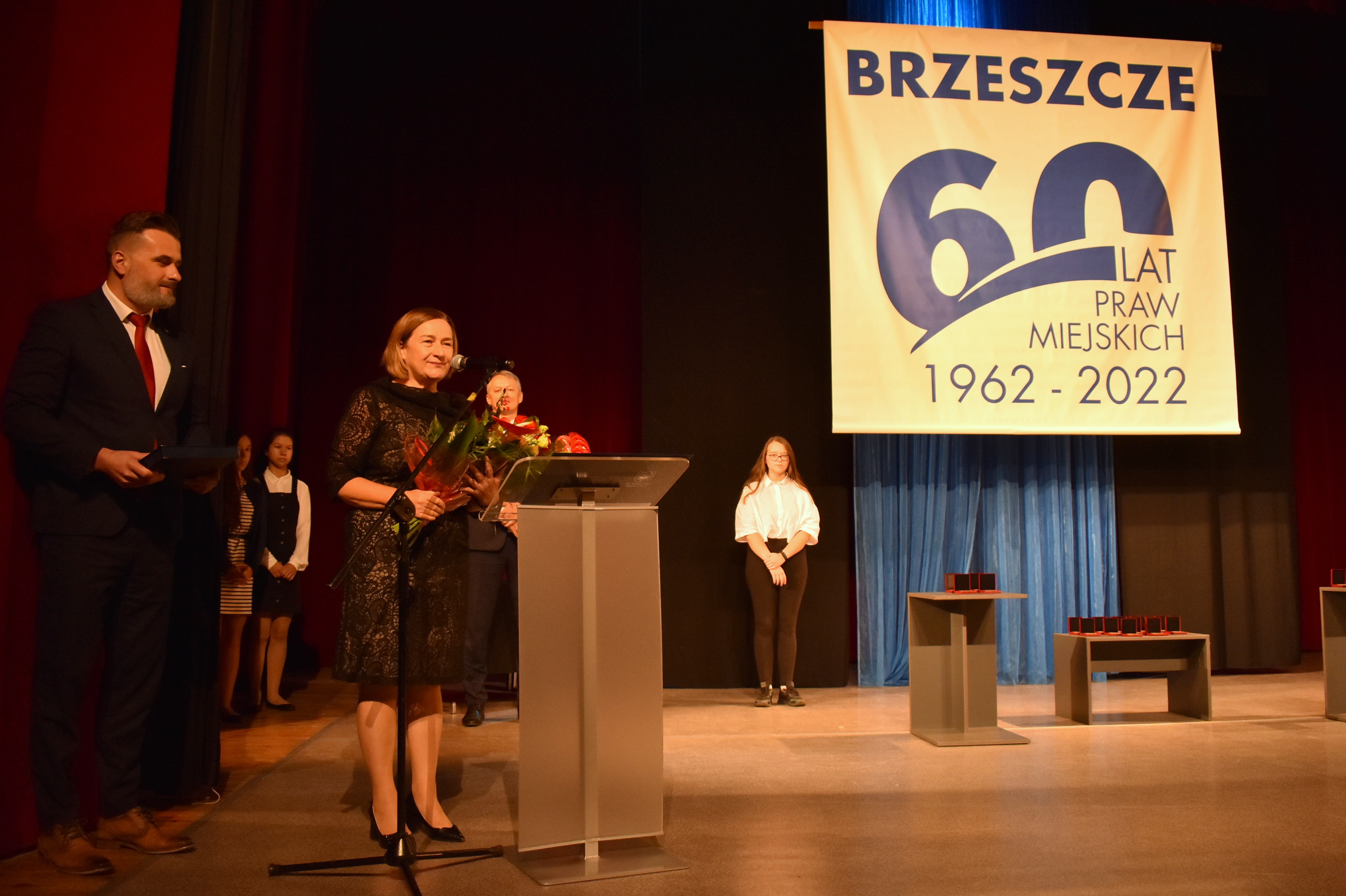 Na zdjęciu członkini zarządu powiatu przemawiająca na scenie ośrodka kultury.