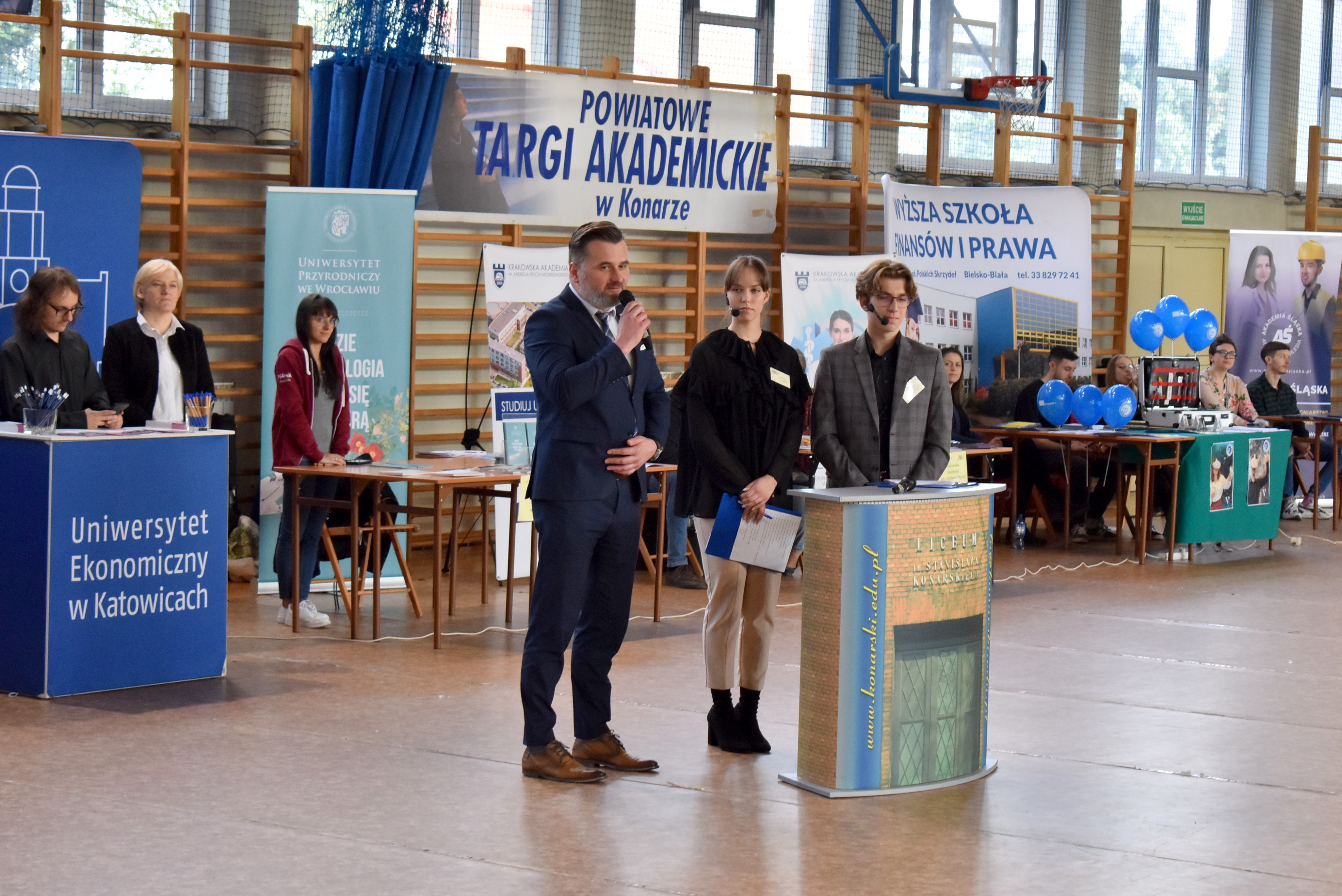 Na zdjęciu przemawiający do uczestników powiatowych targów akademickich wicestarosta. W tle stoiska wybranych uczelni